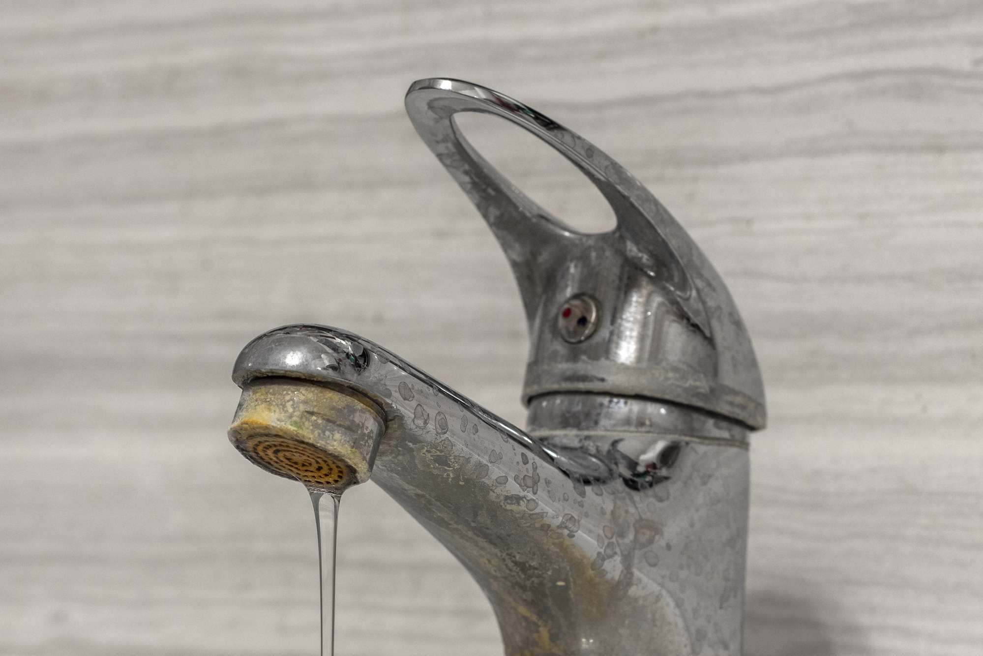 Hard water buildup and hard water stains on a bathroom water fixture
