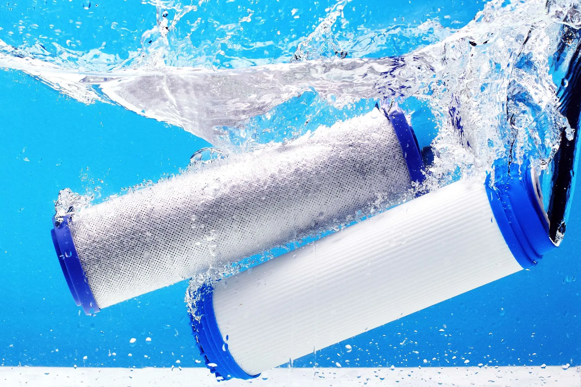 New carbon filter cartridge for house water filtration system isolated on blue background.